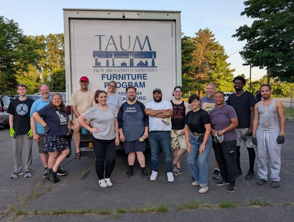 The volunteer crew lined up in front of the TAUM Furniture Program truck.