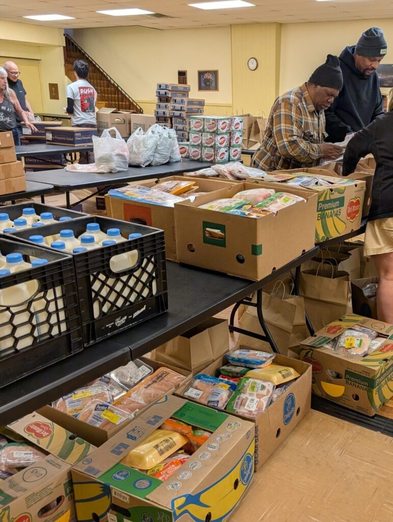 Tables laid out with crates of milk, bread and produce ready for the grocery distribution.