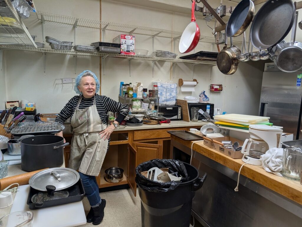 A volunteer in an apron working in the TAUM kitchen.