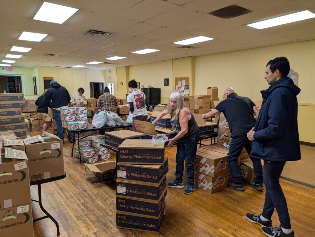 Volunteers sorting boxes of donated food in the community room.