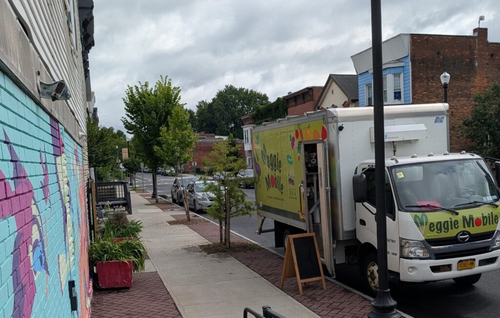 The Veggie Mobile truck parked on Second Street beside the TAUM mural.